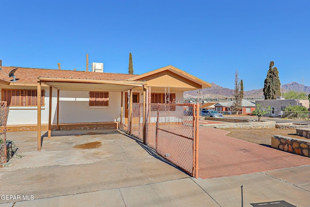 4330 Frankfort Ave, El Paso, TX 79903 - view of front facade with a mountain view, a gate, a carport, and stucco siding