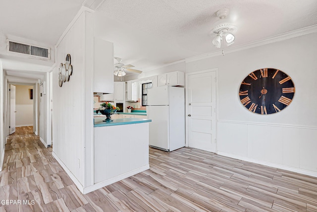 4330 Frankfort Ave, El Paso, TX 79903 - kitchen featuring freestanding refrigerator, a ceiling fan, light wood-style flooring, white cabinets, and ornamental molding