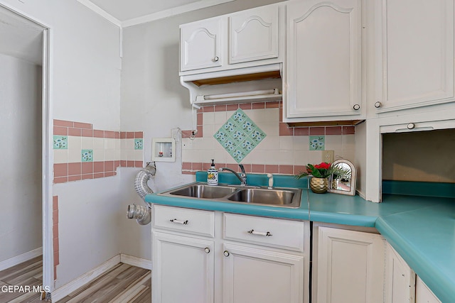 4330 Frankfort Ave, El Paso, TX 79903 - kitchen with backsplash, white cabinets, light wood-style floors, and ornamental molding