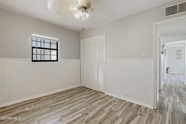 4330 Frankfort Ave, El Paso, TX 79903 - unfurnished bedroom with light wood finished floors, wainscoting, and a closet