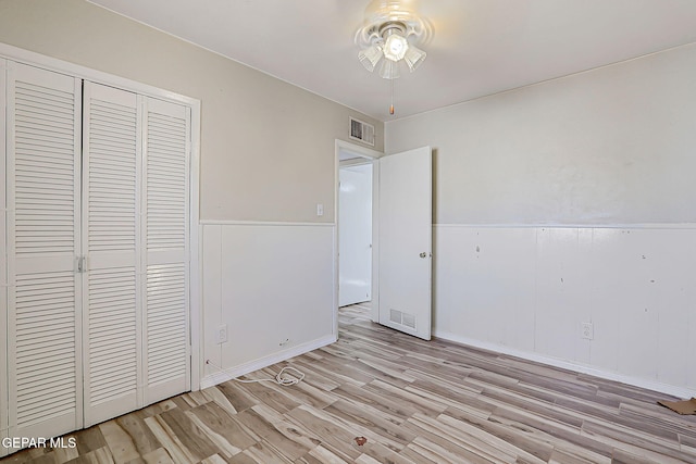 4330 Frankfort Ave, El Paso, TX 79903 - unfurnished bedroom featuring light wood-style flooring, a closet, and a wainscoted wall
