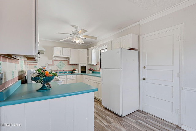 4330 Frankfort Ave, El Paso, TX 79903 - kitchen with freestanding refrigerator, crown molding, a ceiling fan, white cabinetry, and a peninsula