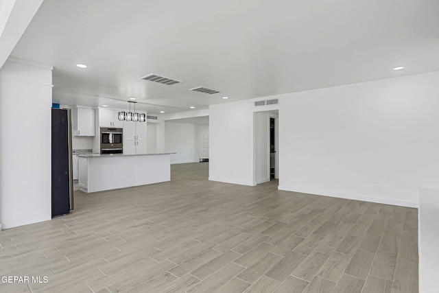 5841 Burning Tree Dr, El Paso, TX 79912 - unfurnished living room with light wood-style flooring and recessed lighting