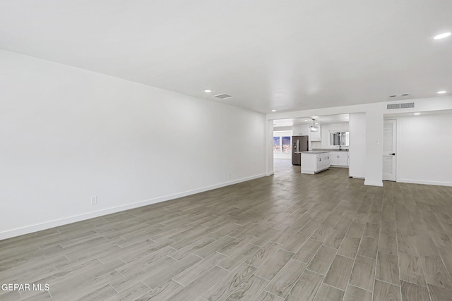 5841 Burning Tree Dr, El Paso, TX 79912 - unfurnished living room with light wood-type flooring and recessed lighting
