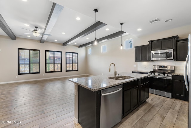 13597 Gatton St, El Paso, TX 79928 - kitchen with stainless steel appliances, beamed ceiling, open floor plan, light wood finished floors, and recessed lighting