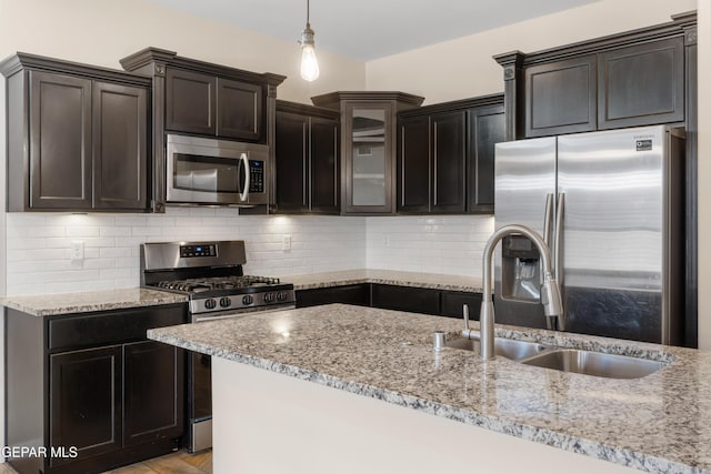 13597 Gatton St, El Paso, TX 79928 - kitchen featuring stainless steel appliances, light stone counters, decorative light fixtures, and glass insert cabinets