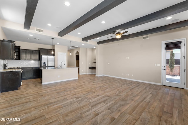 13597 Gatton St, El Paso, TX 79928 - unfurnished living room with arched walkways, beamed ceiling, light wood-type flooring, ceiling fan, and recessed lighting