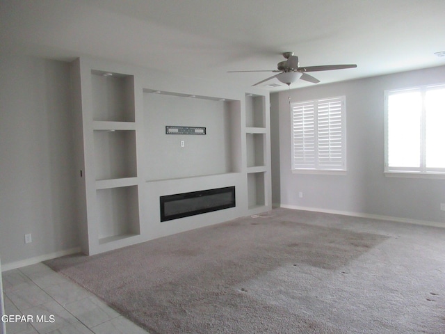 2813 Mike Price Dr, El Paso, TX 79938 - unfurnished living room with a glass covered fireplace, a ceiling fan, and built in features