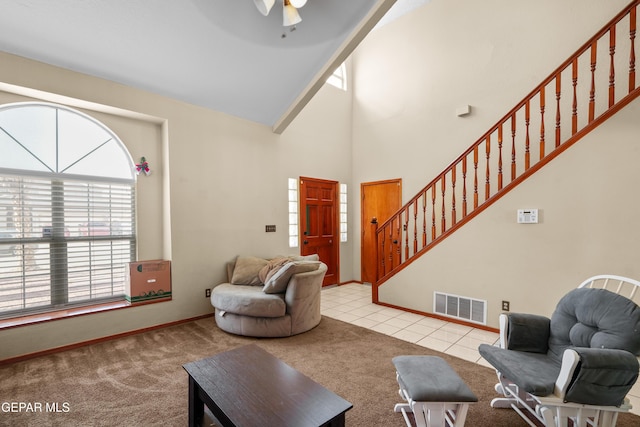 11960 Francis Scobee Dr, El Paso, TX 79936 - carpeted living room with stairway, ceiling fan, tile patterned floors, and high vaulted ceiling