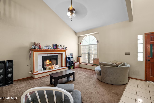 11960 Francis Scobee Dr, El Paso, TX 79936 - tiled living room with high vaulted ceiling, a ceiling fan, a tiled fireplace, and carpet flooring