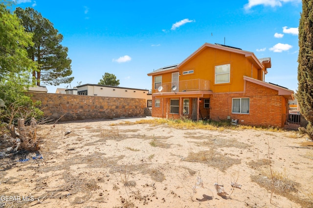 11960 Francis Scobee Dr, El Paso, TX 79936 - back of property with a balcony, brick siding, and roof mounted solar panels