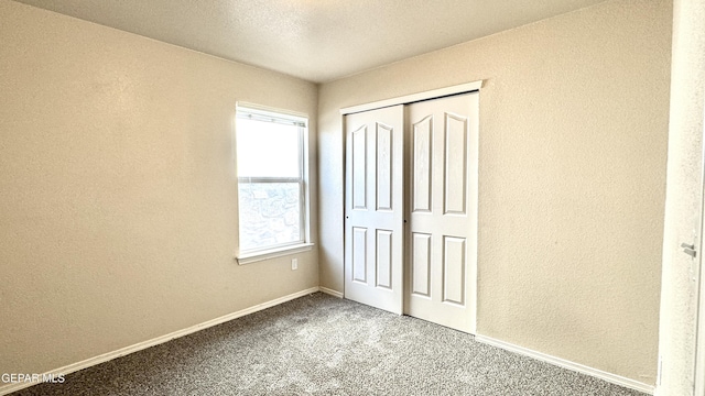 14207 Ranier Point Dr, El Paso, TX 79938 - unfurnished bedroom with carpet flooring, a textured wall, and a closet