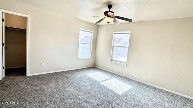 14207 Ranier Point Dr, El Paso, TX 79938 - unfurnished bedroom featuring a walk in closet, carpet floors, a textured ceiling, ceiling fan, and a closet