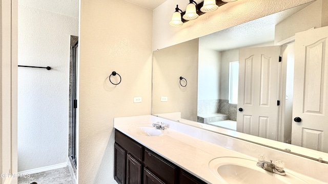 14207 Ranier Point Dr, El Paso, TX 79938 - full bath featuring double vanity, a shower stall, a garden tub, and a textured wall