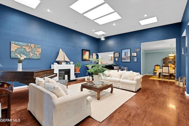 1349 Belvidere St, El Paso, TX 79912 - living room with a high ceiling, a glass covered fireplace, wood finished floors, a skylight, and recessed lighting