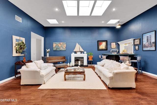 1349 Belvidere St, El Paso, TX 79912 - living area featuring a skylight, recessed lighting, wood finished floors, a towering ceiling, and a glass covered fireplace