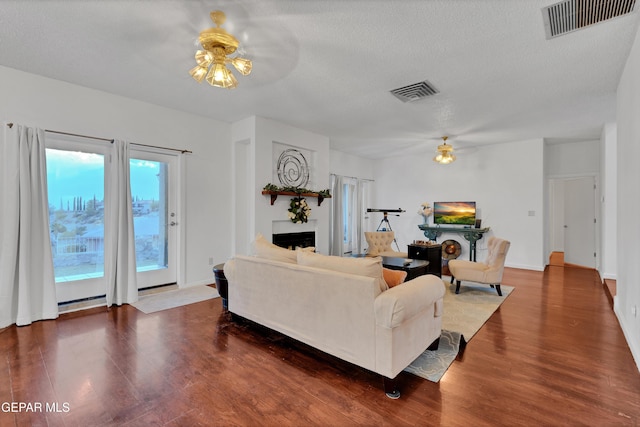 1349 Belvidere St, El Paso, TX 79912 - living room featuring ceiling fan, a fireplace, wood finished floors, and a textured ceiling