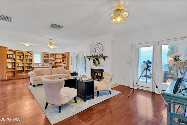 1349 Belvidere St, El Paso, TX 79912 - living area featuring a ceiling fan, a fireplace, healthy amount of natural light, and wood finished floors