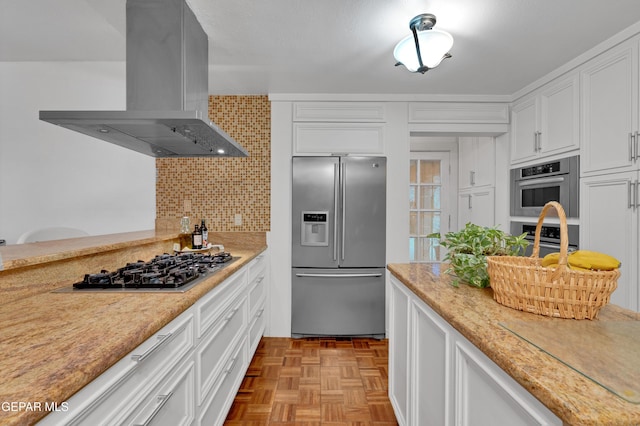 1349 Belvidere St, El Paso, TX 79912 - kitchen featuring appliances with stainless steel finishes, island exhaust hood, white cabinets, and decorative backsplash