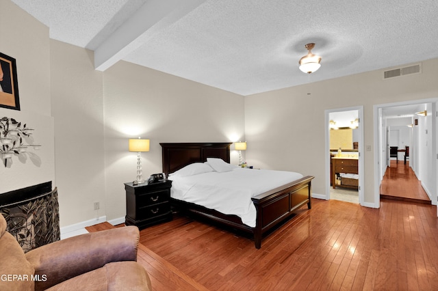 1349 Belvidere St, El Paso, TX 79912 - bedroom with a textured ceiling, hardwood / wood-style floors, beam ceiling, and ensuite bath