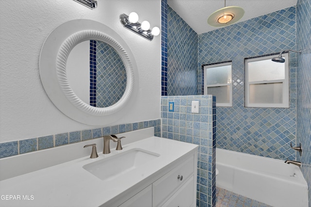 1349 Belvidere St, El Paso, TX 79912 - full bath featuring tile walls, vanity, bathing tub / shower combination, and a textured ceiling