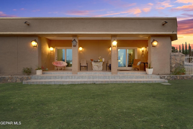 1349 Belvidere St, El Paso, TX 79912 - back of house at dusk with a lawn and stucco siding