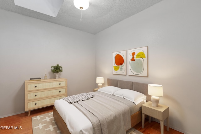 1349 Belvidere St, El Paso, TX 79912 - bedroom featuring wood finished floors, a skylight, and a textured ceiling