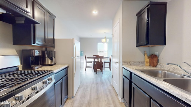 14661 Holly Blue Ave, Horizon City, TX 79928 - kitchen with stainless steel range with gas cooktop, under cabinet range hood, light wood finished floors, light countertops, and recessed lighting