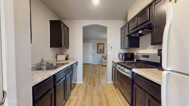 14661 Holly Blue Ave, Horizon City, TX 79928 - kitchen with freestanding refrigerator, gas stove, under cabinet range hood, black microwave, and light wood finished floors