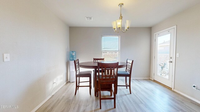 14661 Holly Blue Ave, Horizon City, TX 79928 - dining room featuring light wood-style floors and a chandelier