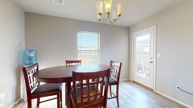 14661 Holly Blue Ave, Horizon City, TX 79928 - dining area with light wood-style flooring and a chandelier