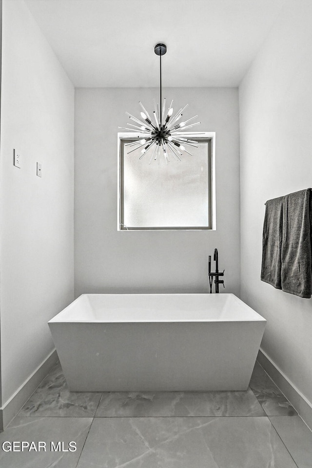 6325 Camino Pinon, El Paso, TX 79932 - bathroom with marble look tiles, a chandelier, and a freestanding bath