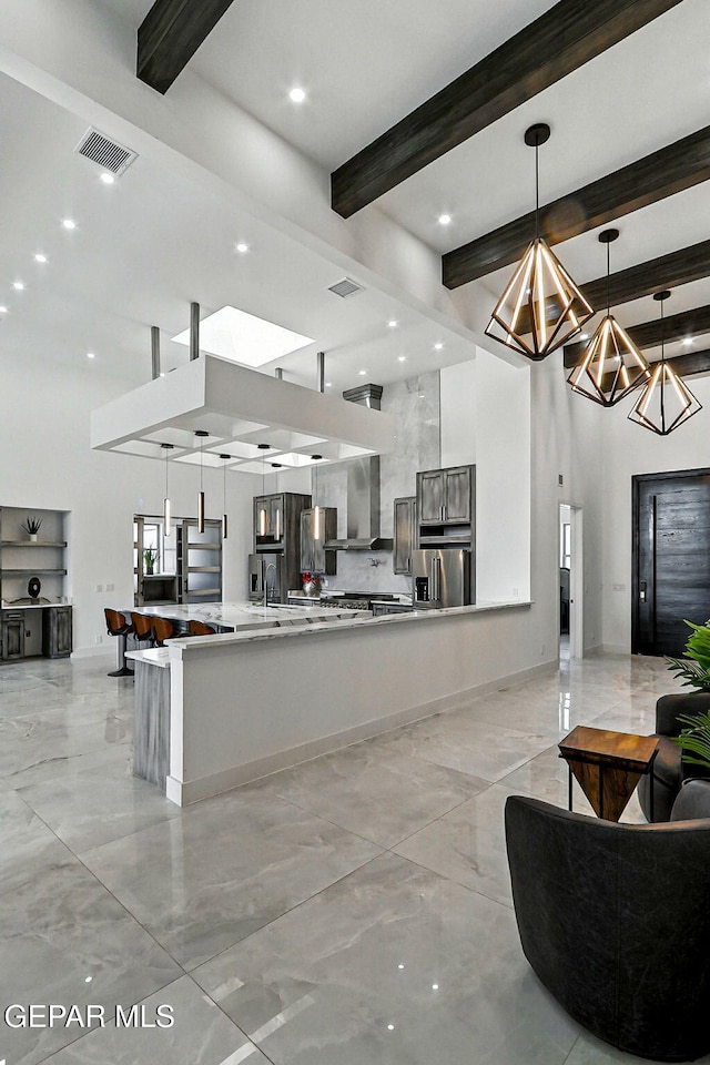 6325 Camino Pinon, El Paso, TX 79932 - kitchen featuring stainless steel refrigerator with ice dispenser, light countertops, beamed ceiling, open floor plan, and wall chimney range hood