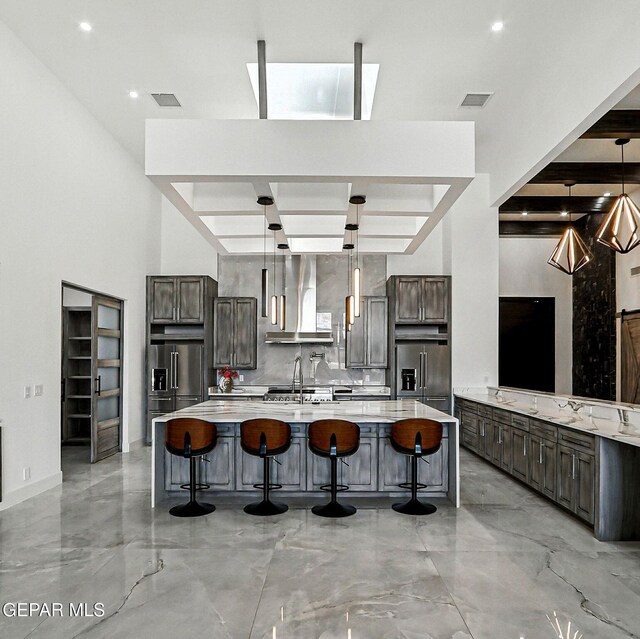 6325 Camino Pinon, El Paso, TX 79932 - kitchen with wall chimney exhaust hood, high end fridge, light countertops, and dark brown cabinetry