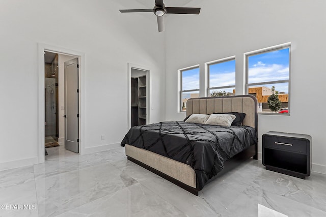6325 Camino Pinon, El Paso, TX 79932 - bedroom featuring light marble finish flooring, a spacious closet, ensuite bathroom, a towering ceiling, and ceiling fan