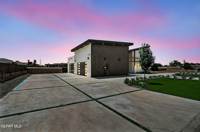 6325 Camino Pinon, El Paso, TX 79932 - outdoor structure at dusk featuring driveway and a garage