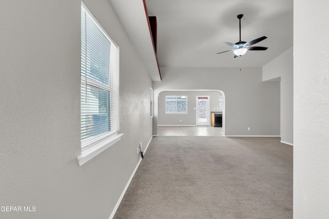 7029 Copper Canyon Dr, El Paso, TX 79934 - unfurnished living room with a ceiling fan, carpet floors, arched walkways, and a textured wall