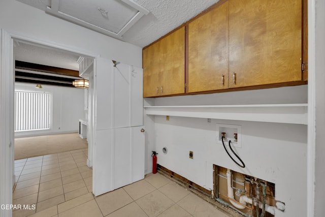 3313 Dublin Rd, El Paso, TX 79925 - washroom with cabinet space, hookup for an electric dryer, washer hookup, light tile patterned flooring, and a textured ceiling