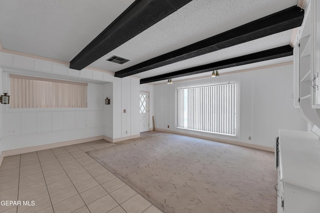 3313 Dublin Rd, El Paso, TX 79925 - unfurnished living room with beamed ceiling, light tile patterned floors, and a textured ceiling