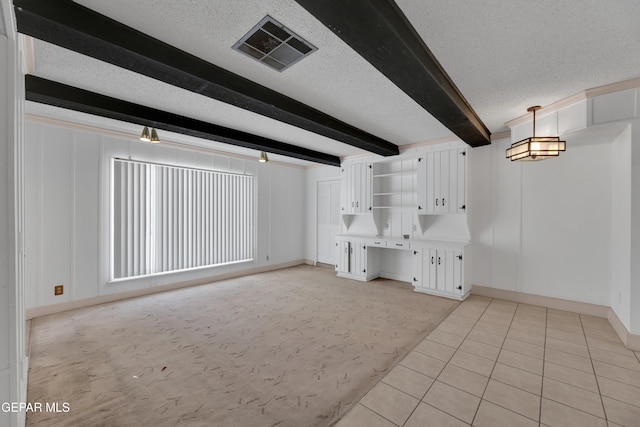 3313 Dublin Rd, El Paso, TX 79925 - unfurnished living room featuring a textured ceiling, beam ceiling, light tile patterned flooring, and light colored carpet