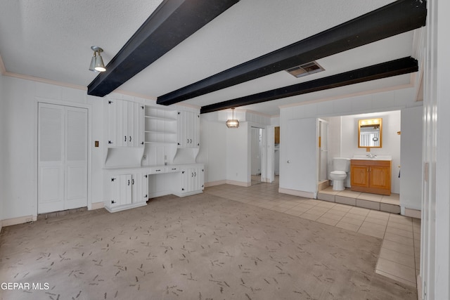 3313 Dublin Rd, El Paso, TX 79925 - unfurnished living room with beam ceiling and light tile patterned floors