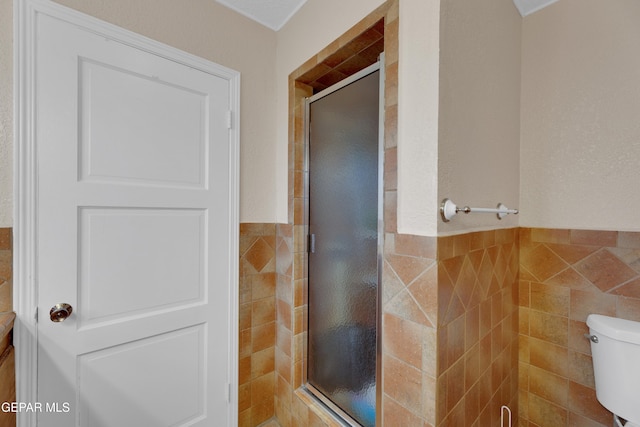 3313 Dublin Rd, El Paso, TX 79925 - bathroom with tile walls, a shower stall, and wainscoting