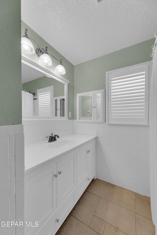 3313 Dublin Rd, El Paso, TX 79925 - bathroom with vanity, tile walls, and a textured ceiling
