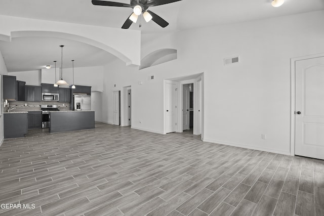 14373 Nick Drahos Ln, Horizon City, TX 79928 - unfurnished living room featuring high vaulted ceiling, ceiling fan, and light wood-style flooring