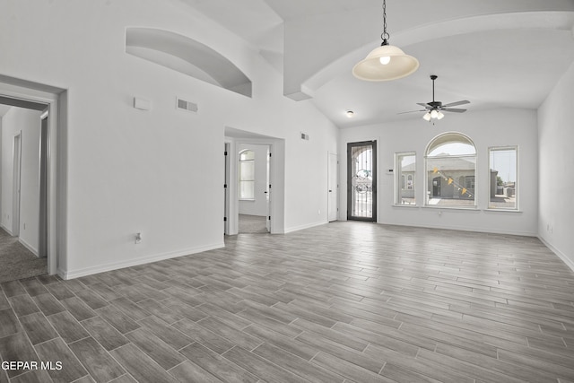 14373 Nick Drahos Ln, Horizon City, TX 79928 - unfurnished living room featuring healthy amount of natural light, a ceiling fan, wood finished floors, and high vaulted ceiling