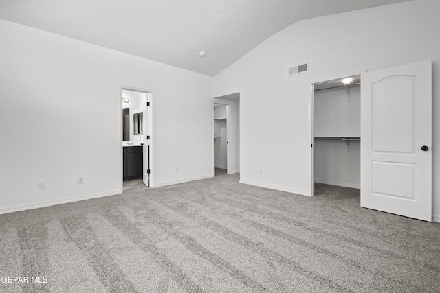 14373 Nick Drahos Ln, Horizon City, TX 79928 - unfurnished bedroom featuring a walk in closet, carpet flooring, high vaulted ceiling, and connected bathroom