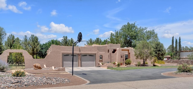 981 Vereda Del Valle Ave, El Paso, TX 79932 - pueblo-style home featuring an attached garage, driveway, and stucco siding