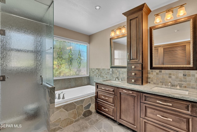 981 Vereda Del Valle Ave, El Paso, TX 79932 - bathroom featuring double vanity, a garden tub, a shower stall, and decorative backsplash
