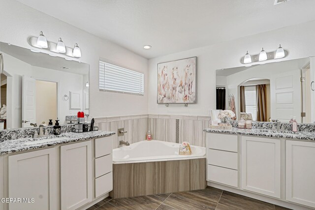 13847 Alamito Creek Ave, Clint, TX 79836 - full bathroom featuring two vanities and a garden tub