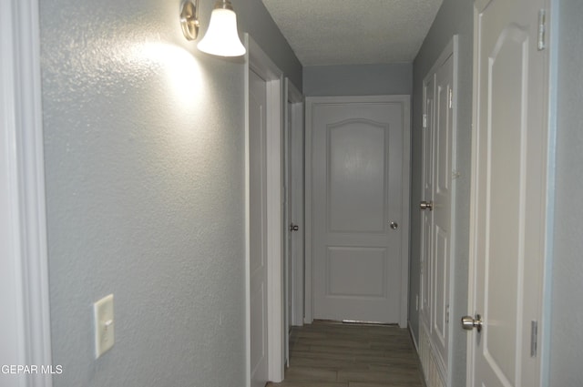 14309 Desierto Bueno Ave, Horizon City, TX 79928 - hallway featuring wood finished floors, a textured wall, and a textured ceiling